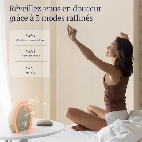 Une femme s'étirant sur un lit, le radio réveil et le coussin vibrant sur une table basse. Texte 'Réveillez-vous en douceur g...