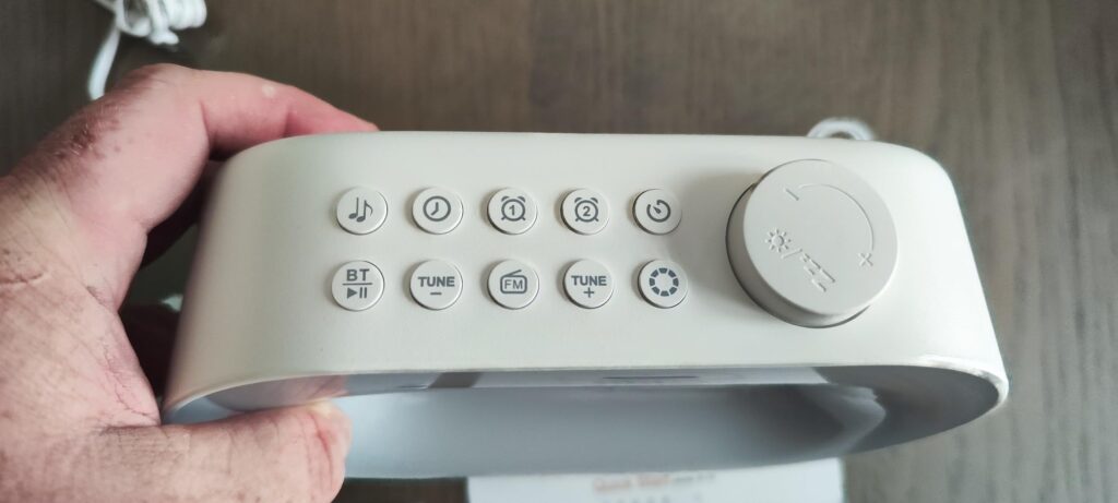 Gros plan sur les boutons de contrôle et la molette du radio-réveil.