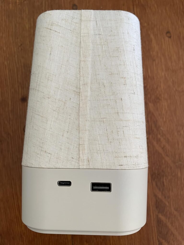 Appareil sur fond de table en bois, vu de derrière, avec les ports USB visibles.