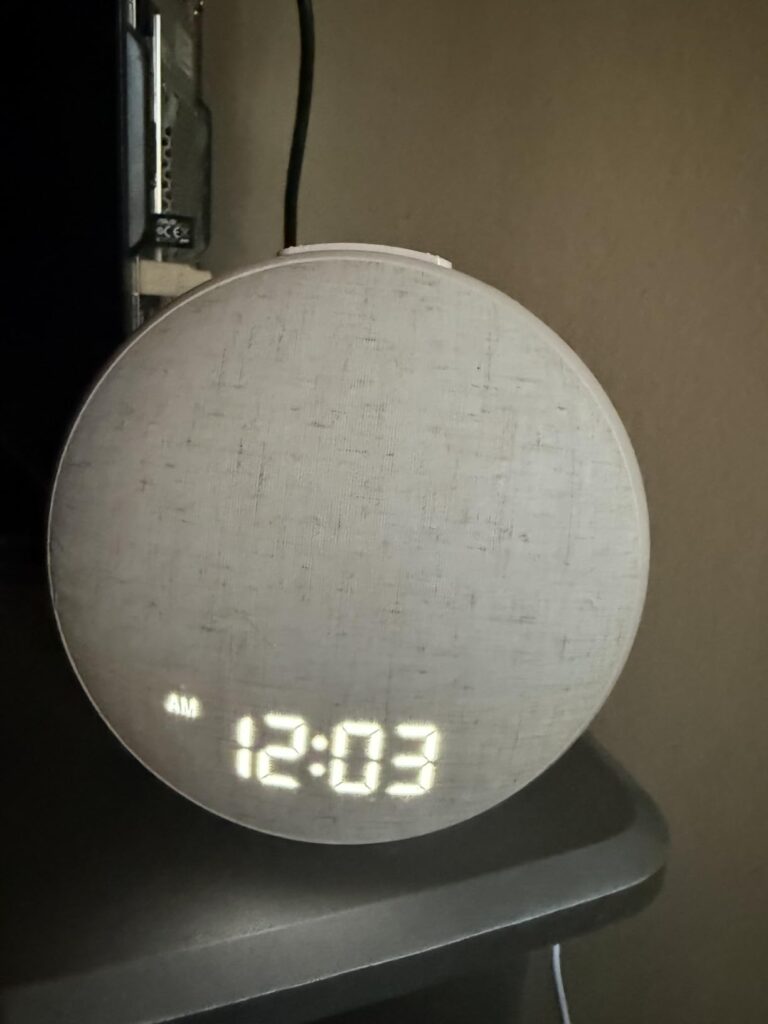 Vue de face du réveil lumineux éteint, affichant l'heure et une icône d'alarme.
