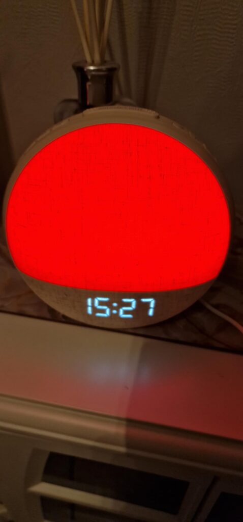Vue de face du réveil lumineux en fonctionnement, affichant l'heure. La lumière est rouge.