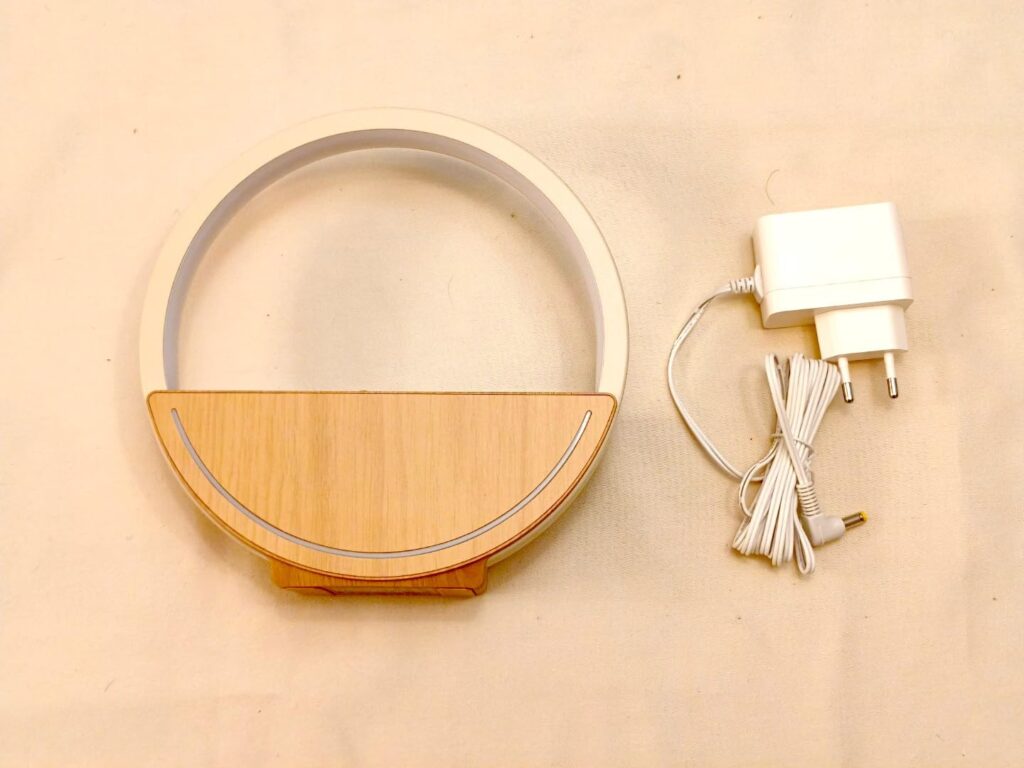 Vue d'ensemble du diffuseur d'huiles essentielles et de son adaptateur secteur, sur fond clair. Le diffuseur est en forme de...