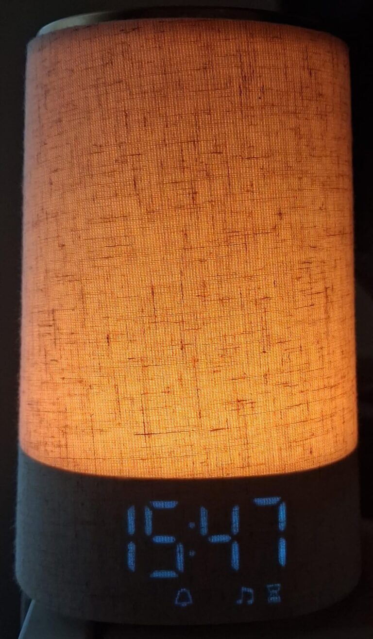 Le produit est allumé, affichant l'heure 15:47 et un éclairage d'ambiance orangé.