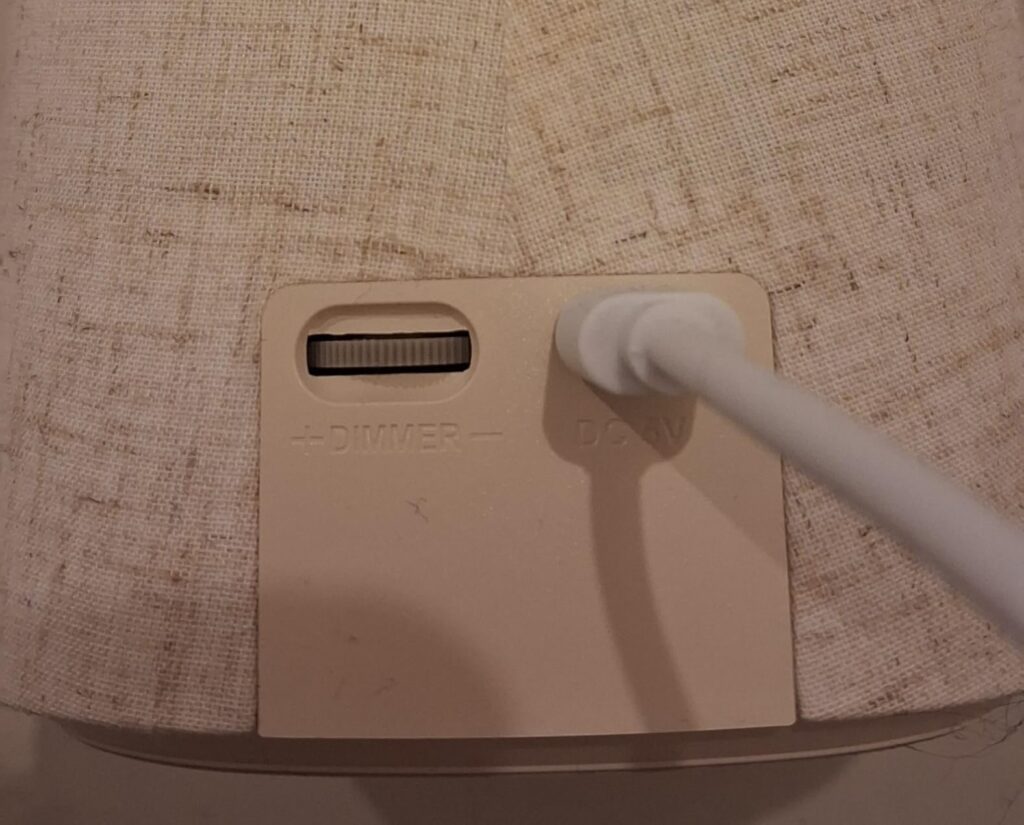 Vue détaillée de l'arrière de l'enceinte, montrant le bouton de réglage du volume, la prise d'alimentation et un câble.