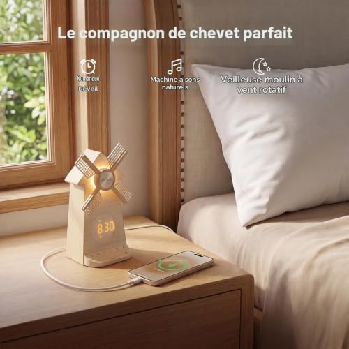 Réveil moulin posé sur une table de chevet à côté d'un lit avec un téléphone en charge. Du texte décrit ses fonctions.