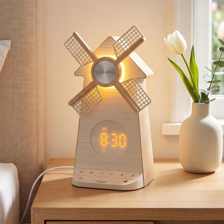 Réveil en forme de moulin à vent posé sur une table de chevet, avec l'heure affichée et les pales illuminées. Une fleur blanc...
