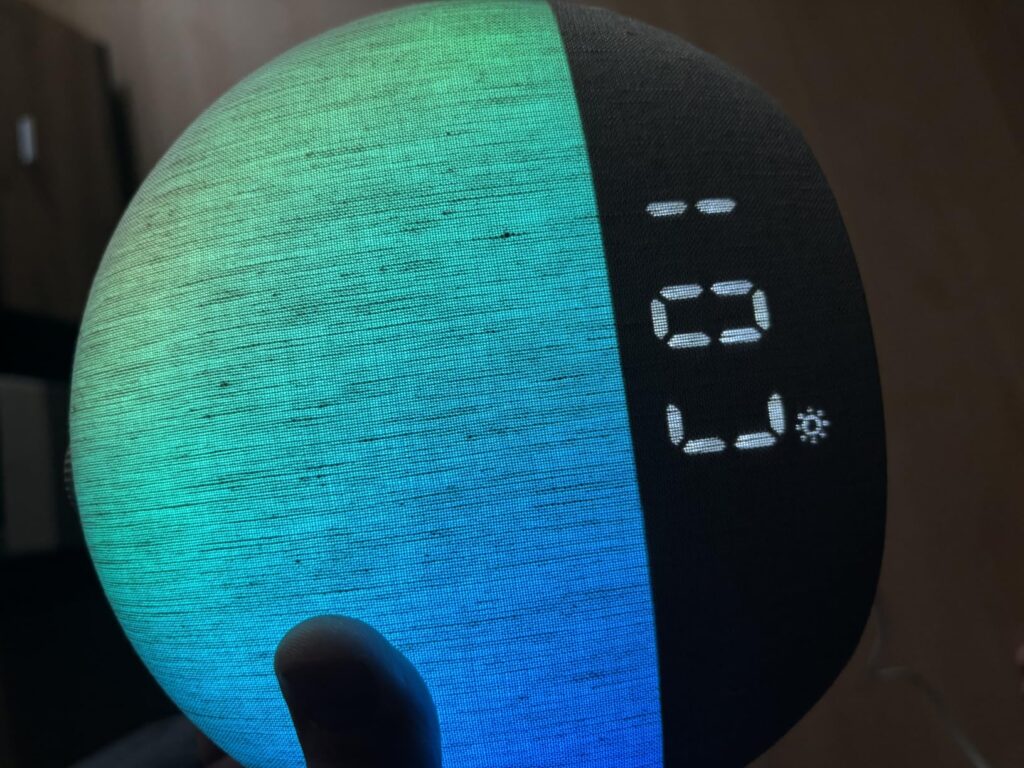 Vue de face du réveil, allumé avec une lumière colorée, affichant l'heure.