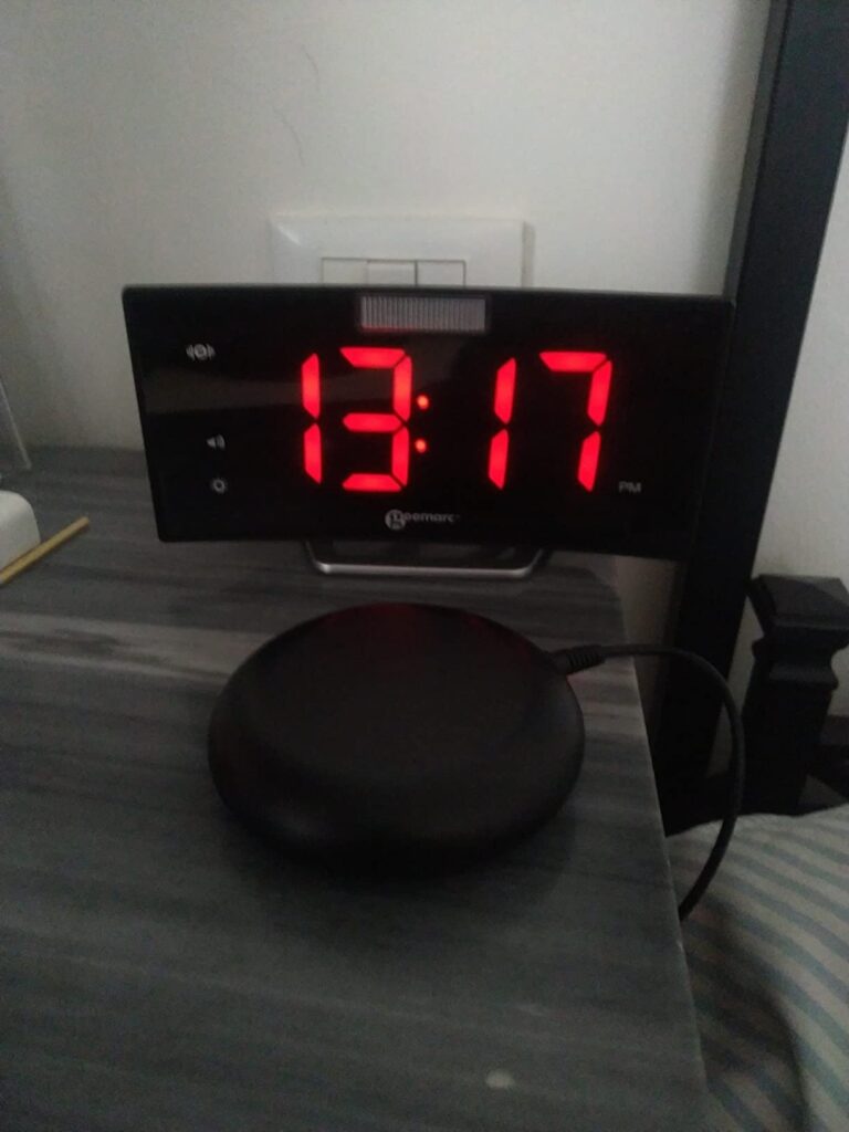 Le réveil et son vibreur posés sur une table de nuit