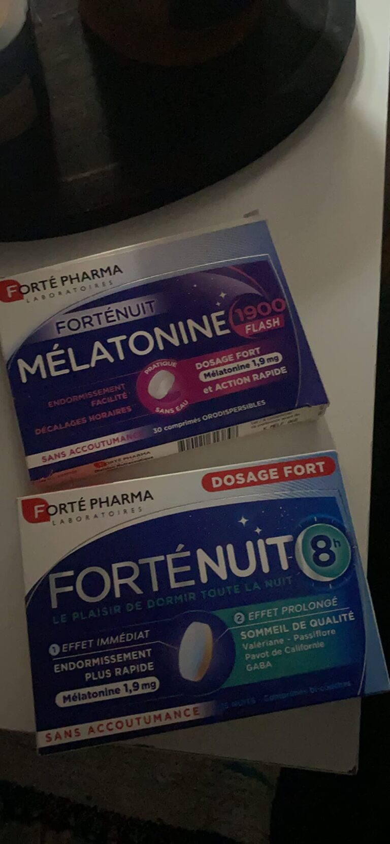 Deux boîtes de Forté Pharma Melatonine et Fortenuit 8 sur un fond sombre.