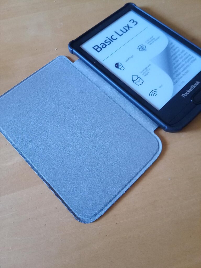 Liseuse Pocketbook Basic Lux 3 avec sa coque ouverte, posée sur une table en bois.