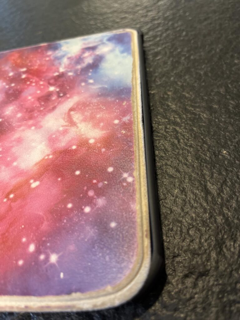 Gros plan sur le coin de la liseuse avec la coque galaxie, montrant l'épaisseur.