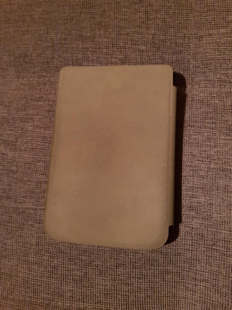 Liseuse Pocketbook avec une coque beige fermée.