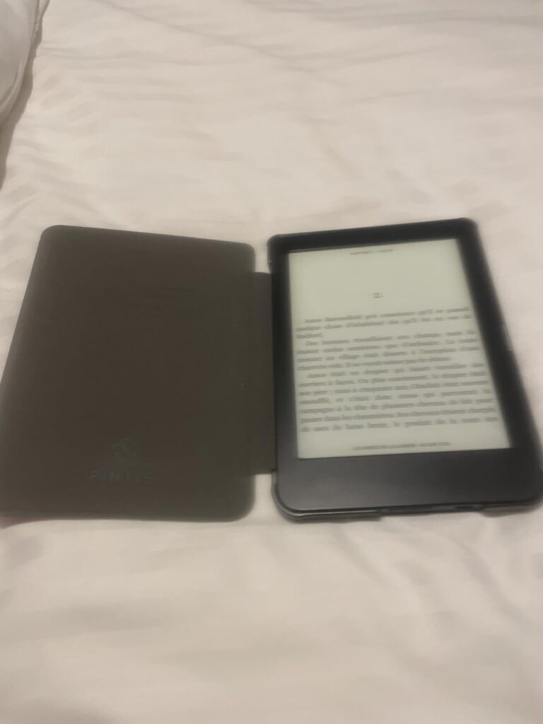 Liseuse Kobo avec coque ouverte affichant une page de texte, posée sur un tissu blanc. C'est le même visuel que le 0, sous un...
