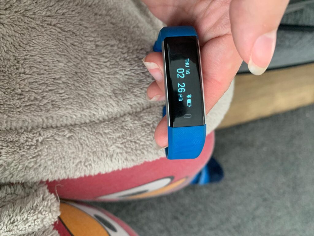 Le même bracelet connecté bleu, l'écran affichant l'heure