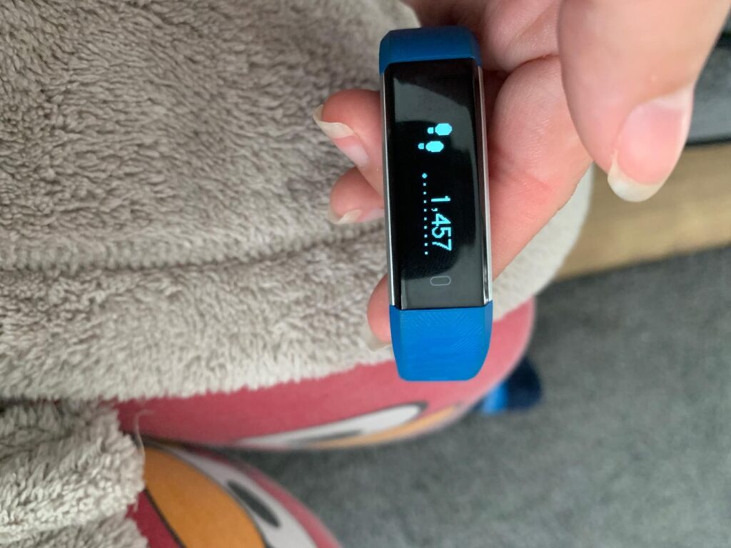 Le même bracelet connecté bleu, l'écran affichant le nombre de pas