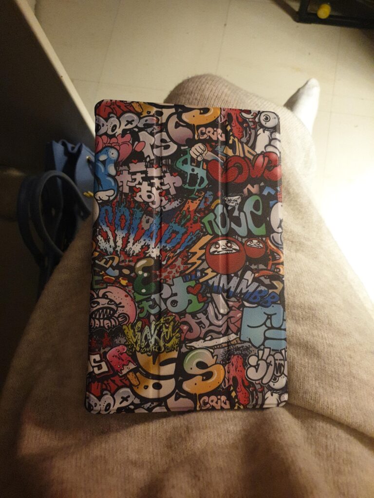 Étui de tablette avec motif graffiti, posé sur les genoux d'une personne