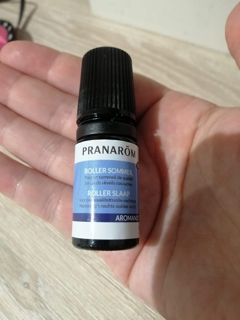 Flacon de roller Sommeil de Pranarôm tenu dans une main ouverte.