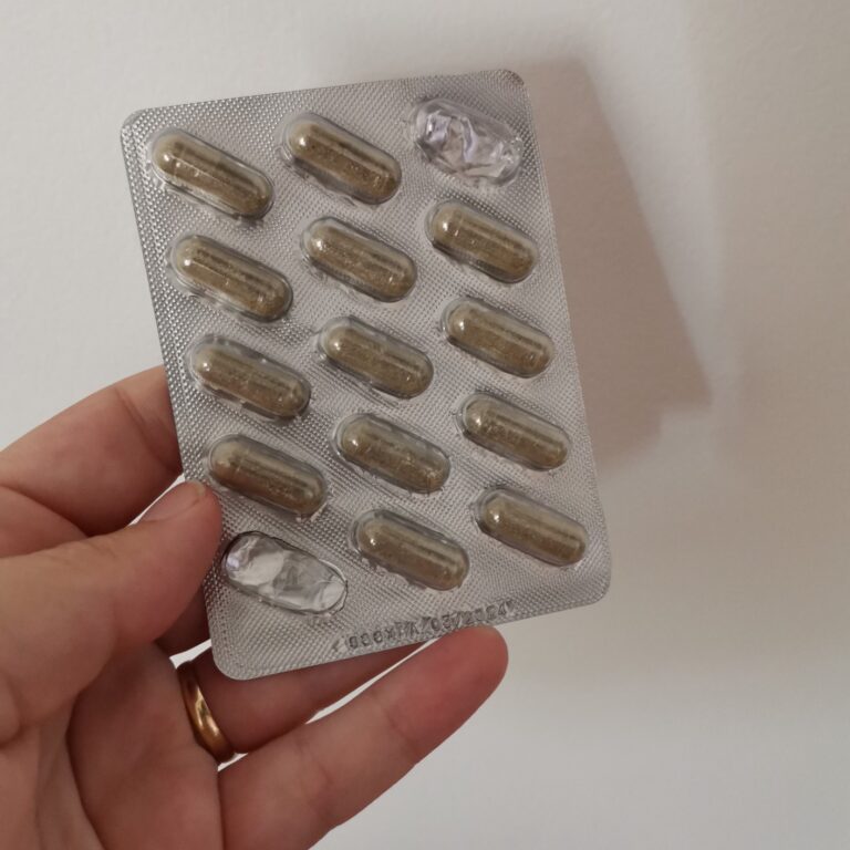Blister de 15 gélules de Sommeil Bio tenu dans la main. Une gélule a été retirée en bas à gauche, une autre en haut à droite.
