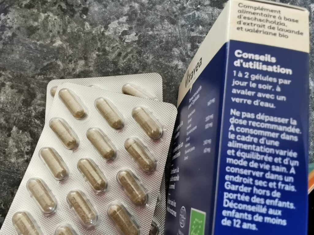 Paquet de Sommeil Bio posé sur une surface texturée, vue de côté. Un blister de gélules est posé devant le paquet.