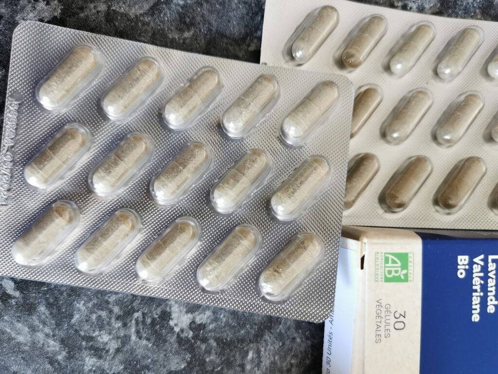 Deux blisters de 15 gélules et un coin du paquet de Sommeil Bio posés sur une surface texturée. Un des blisters est complet,...