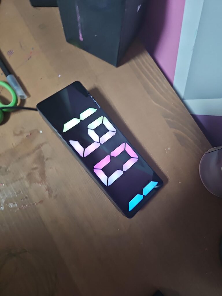 Vue du réveil affichant l'heure 19:02 sur une table.