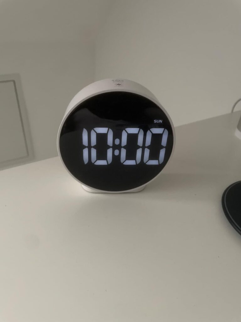 Le réveil sur une table de chevet, l'heure affichée est 10h00.