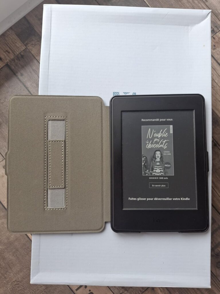 Liseuse Kindele Paperwhite dans son étui ouvert, sur un fond blanc. Le livre "Kindle Paperwhite User's Guide" est affiché à l...