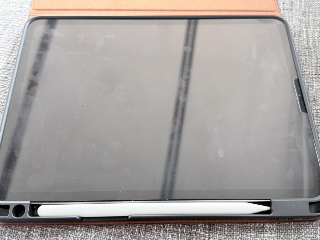 Vue de face de la tablette dans sa coque, avec le stylet dans son logement.