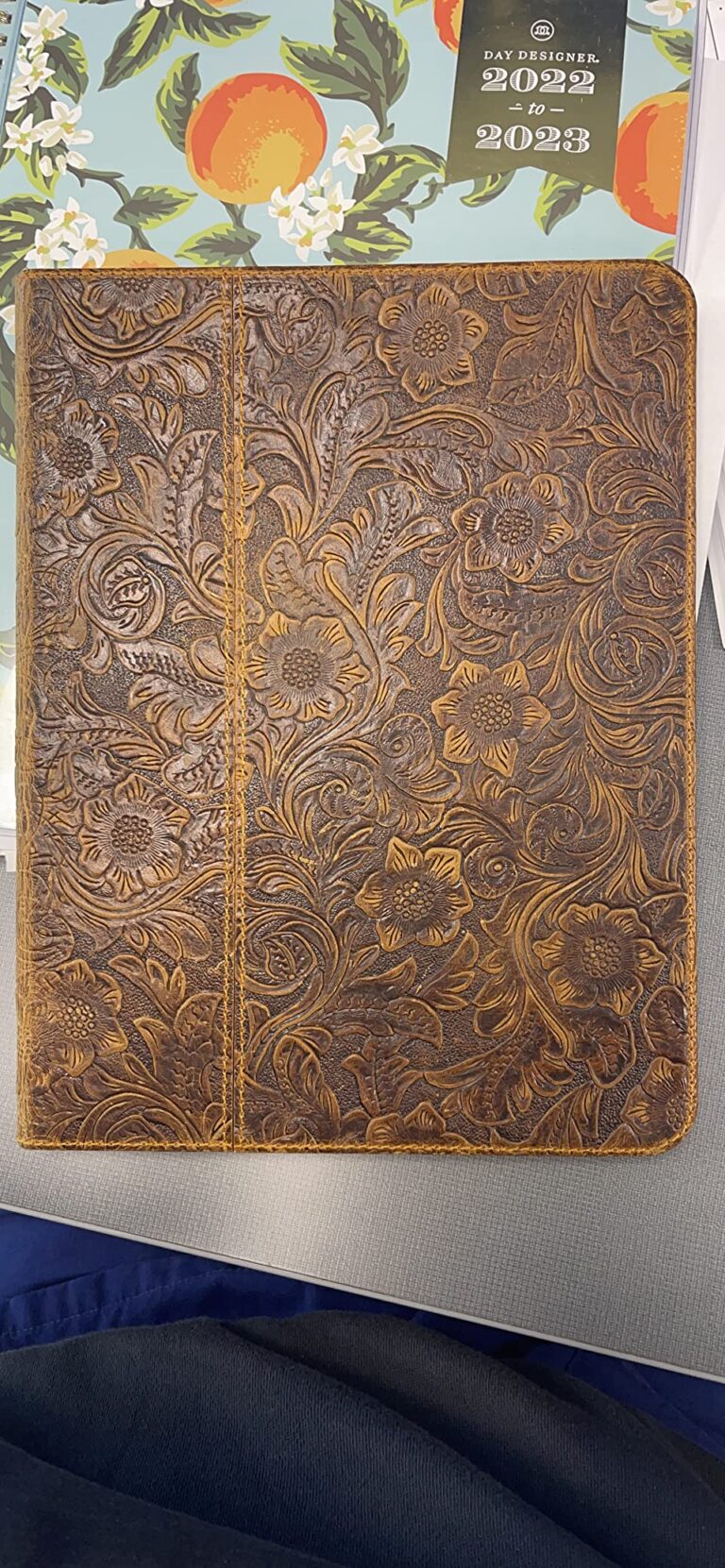 Vue de dos de la coque en cuir marron avec des motifs floraux, dans un environnement.