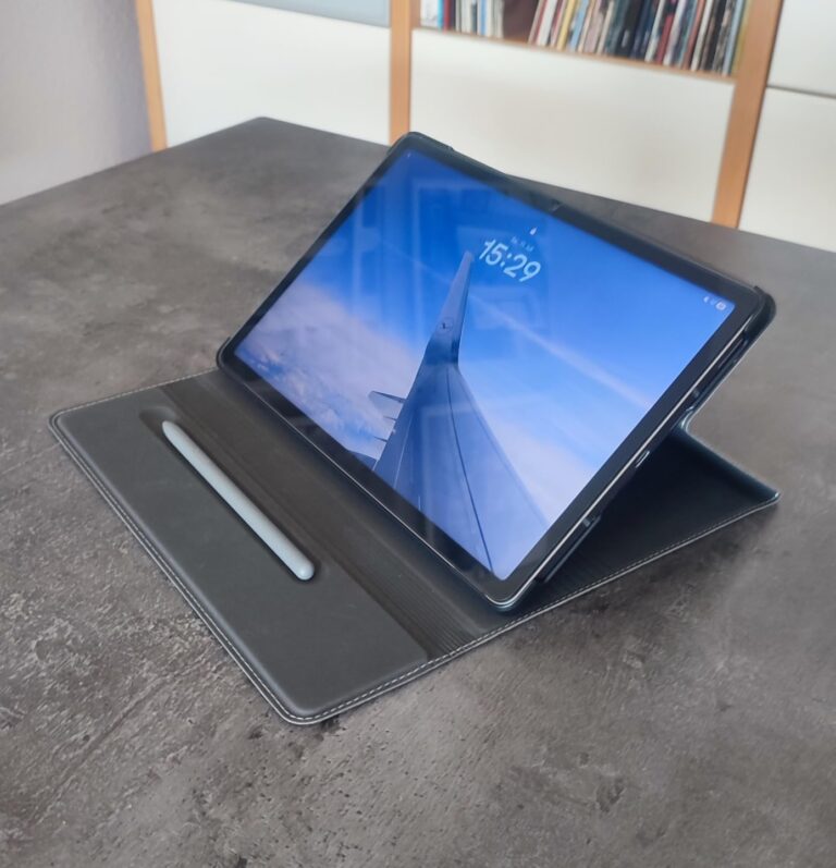Tablette dépliée en mode paysage sur une table, avec l'heure affichée