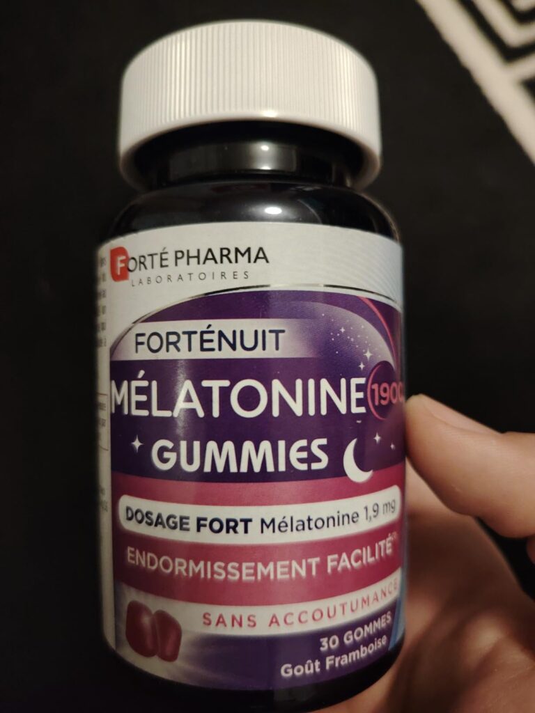 Gros plan sur le flacon de mélatonine, tenu par une main, avec le texte promotionnel bien visible.