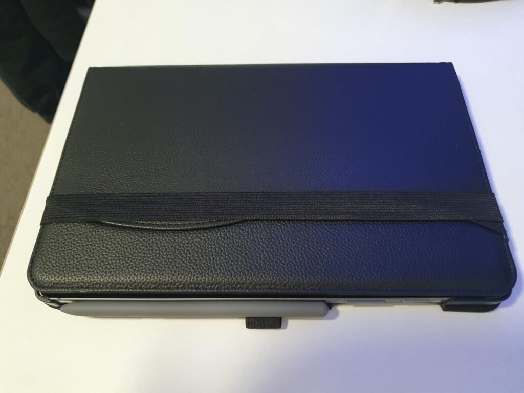 Vue de dessus d'une coque de tablette noire fermée avec une sangle élastique.