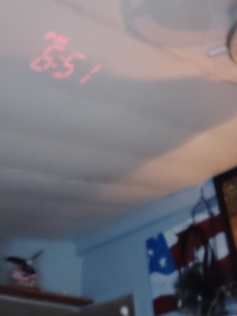 Projection de l'heure 8:51 sur un plafond avec une ambiance de chambre.
