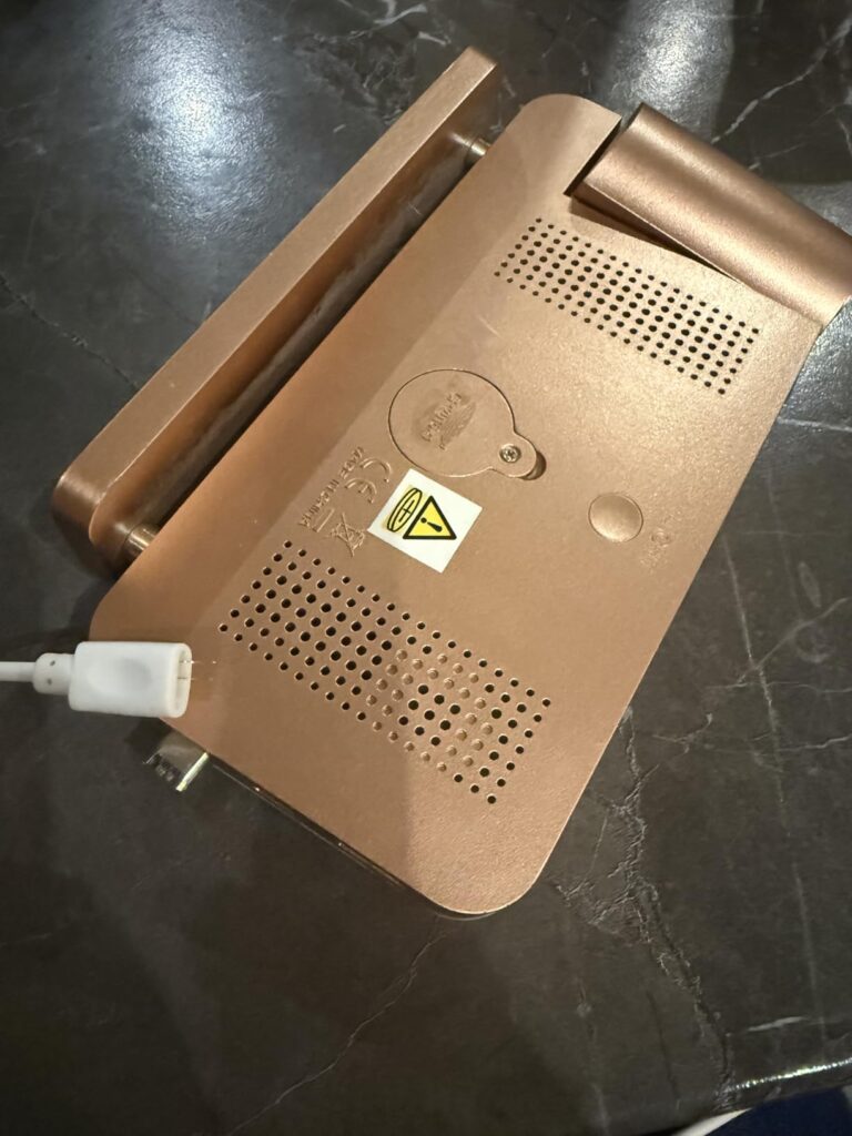Vue du dessous d'un réveil, montrant les fiches de connexion et le port de charge.