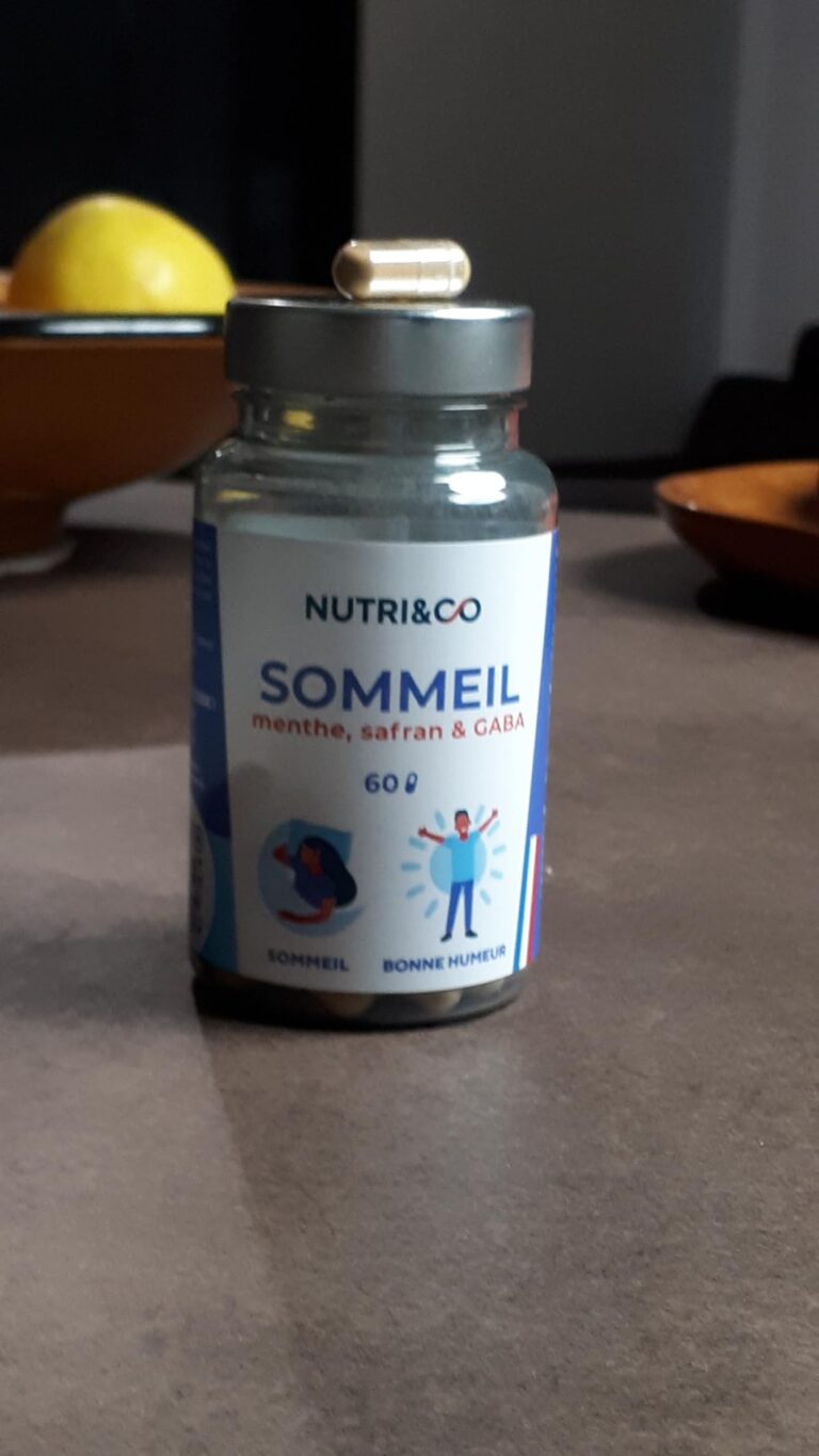 La bouteille de compléments alimentaires est posée sur une table, avec une gélule sur le couvercle. L'arrière-plan est flou.