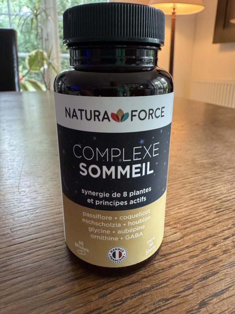Flacon du complément alimentaire Complexe Sommeil de Natura Force posé sur une table en bois.
