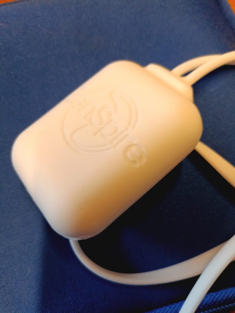 Gros plan sur le boîtier de contrôle du masque de relaxation ZenSpire avec le logo ZenSpire visible.