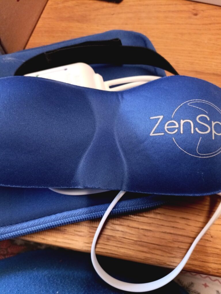 Le masque de relaxation ZenSpire posé sur sa pochette de transport.
