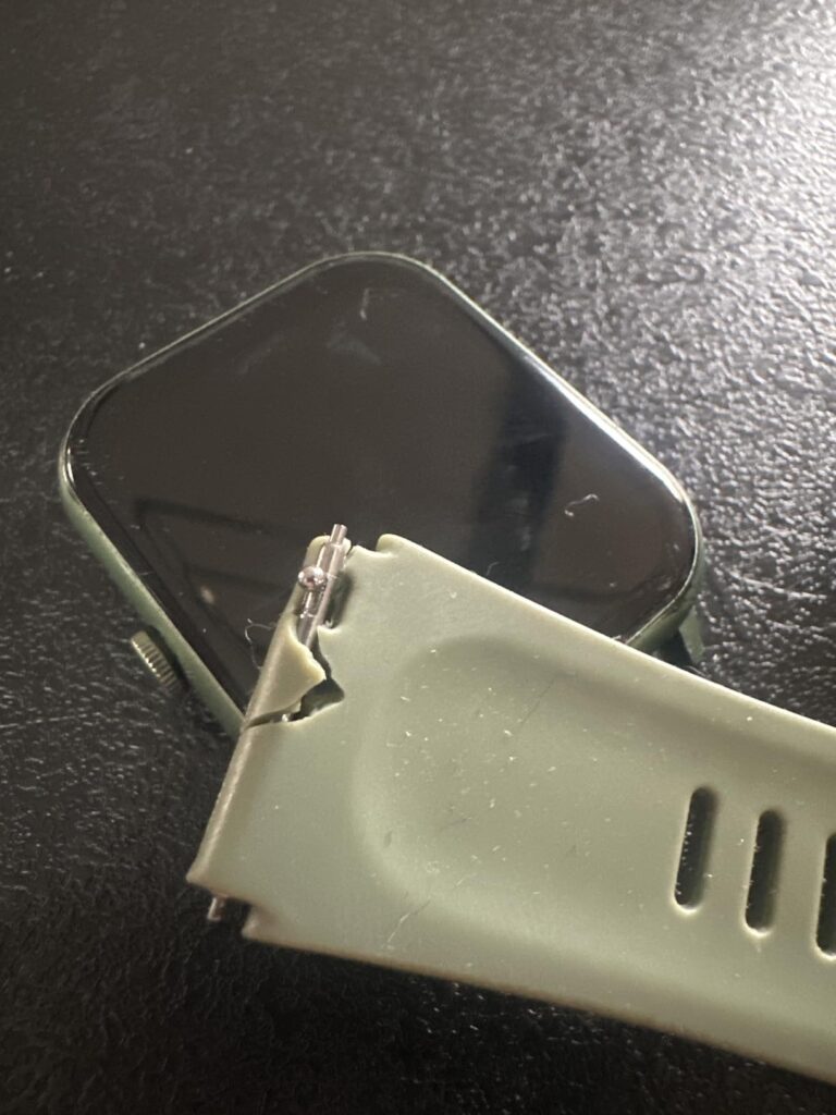 Gros plan sur une montre connectée grise avec un bracelet cassé.