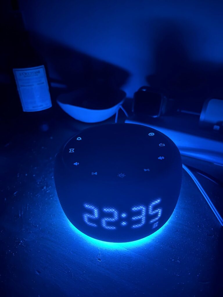 Le réveil lumière de nuit éteinte, l'heure est affichée en bleu. Vue de dessus.
