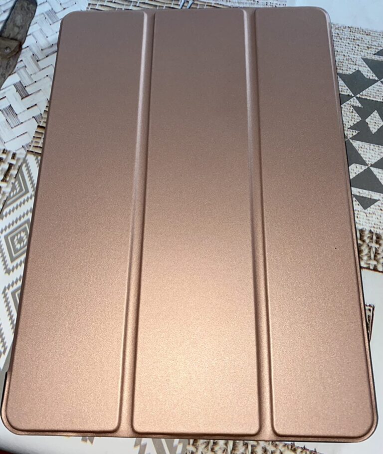 Vue de dessus de la même coque marron/dorée fermée, sur un tissu. Même visuel que le visuel 1, mais sur un fond différent.