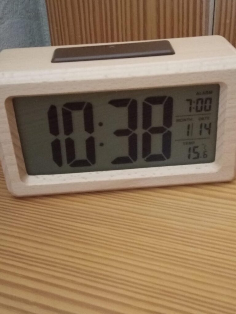 Vue de face du réveil avec affichage de l'heure 10:38, de l'alarme, de la date et de la température 15°C.