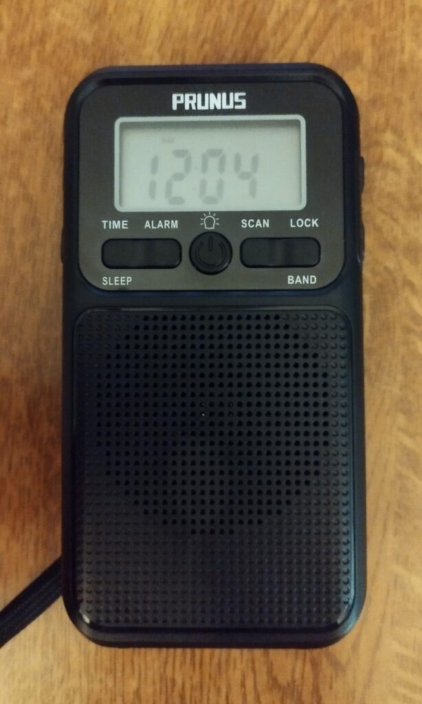 Le poste de radio posé sur une table en bois, l'écran affiche l'heure.
