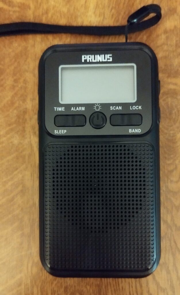 Le poste de radio posé sur une table en bois, l'écran est éteint.