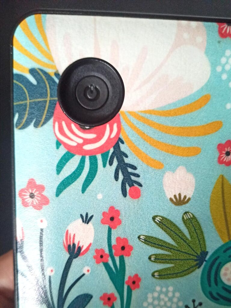Gros plan sur le bouton d'allumage noir rond de la coque avec le motif floral.