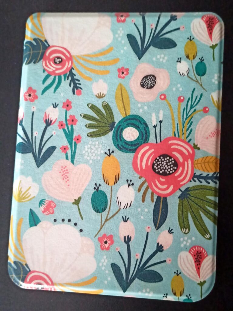 Coque de liseuse avec un motif floral coloré, vue de dessus, fermée.
