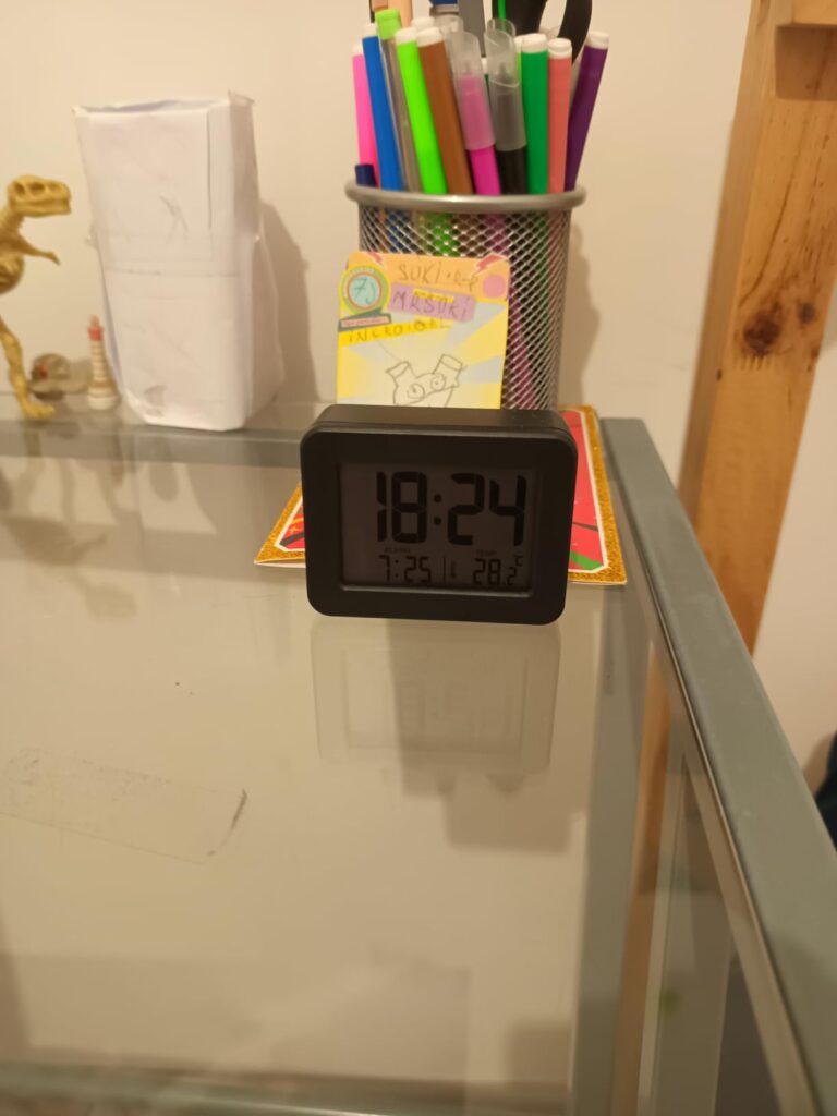 Le réveil sur un bureau, avec l'heure affichée.