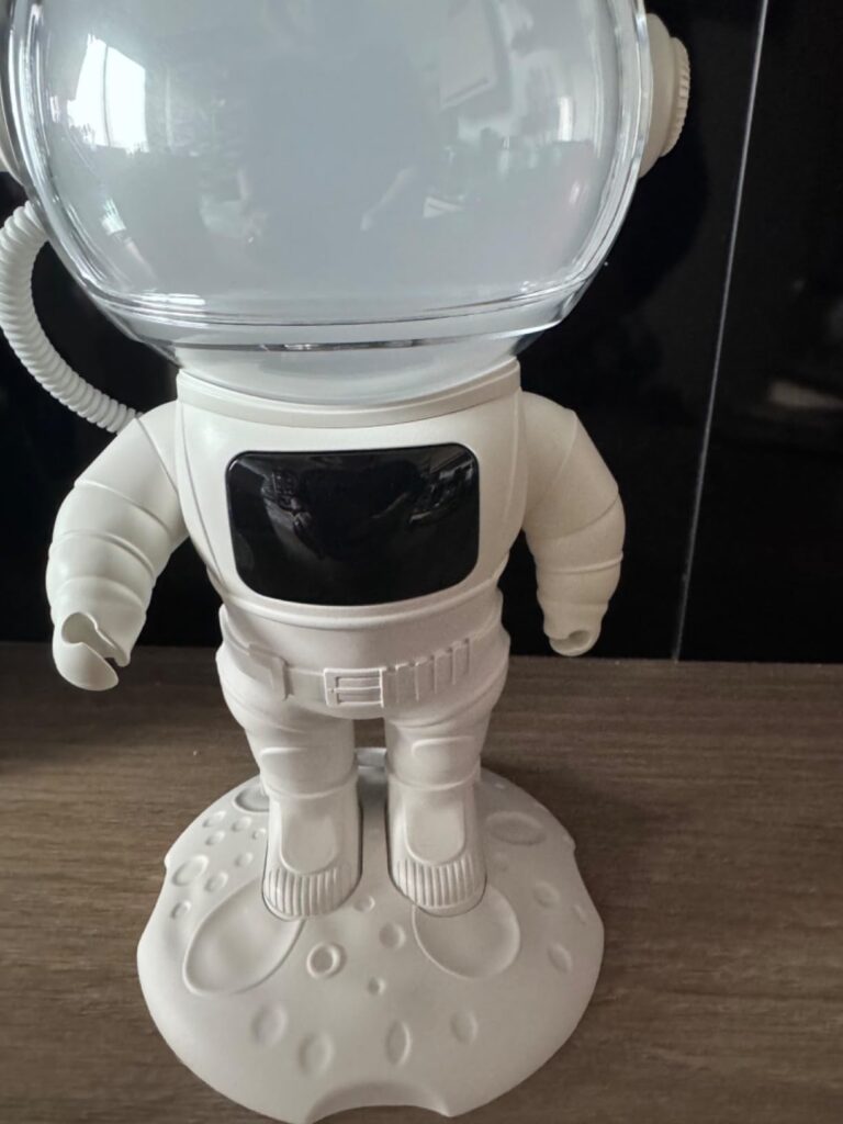 Vue de face du projecteur astronaute, légèrement de côté. La visière est transparente, sans lumière. Le corps de l'astronaute...