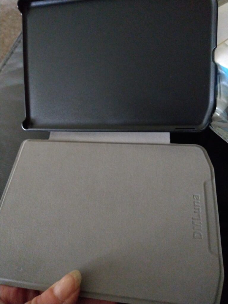 Vue intérieure de la coque de protection ouverte, montrant le rabat gris et la partie noire de maintien de la liseuse.