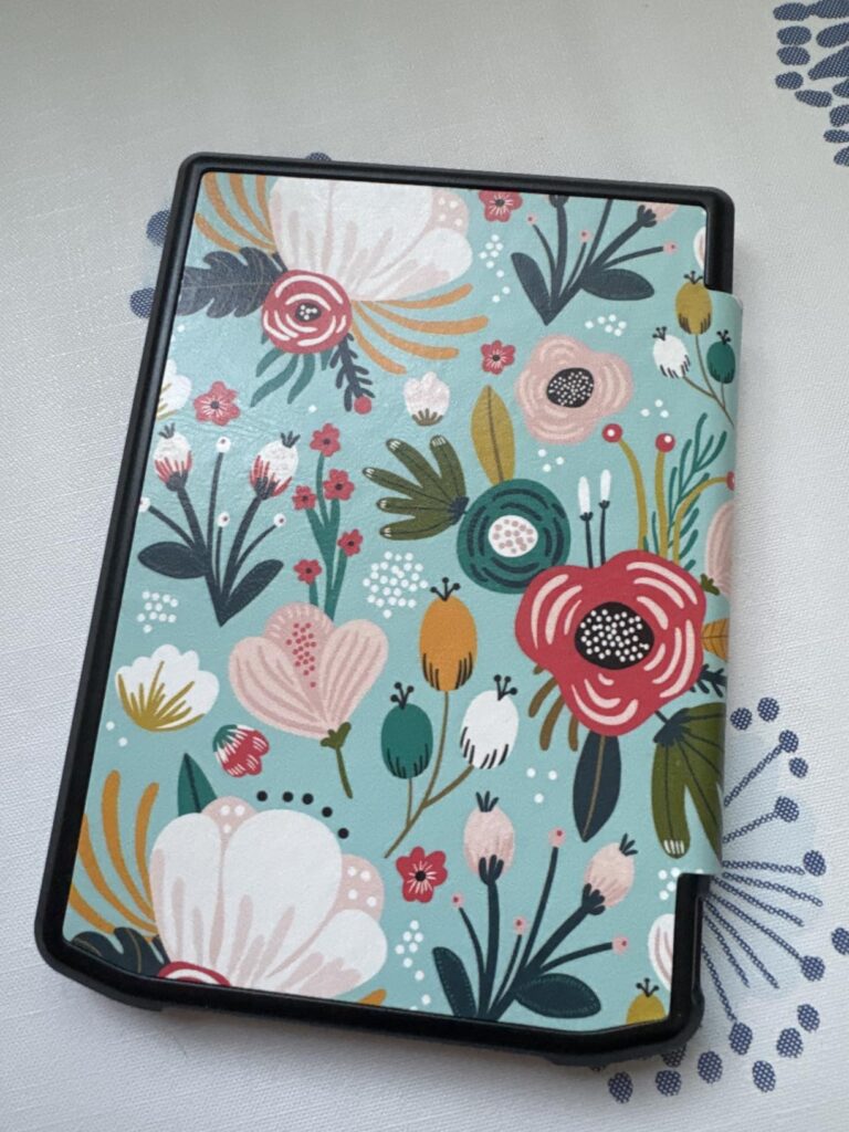Vue oblique de la coque de protection fermée avec la liseuse à l'intérieur, montrant le motif floral et les bords de la coque...